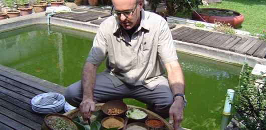 a man sitting on a ledge with a bowl of food